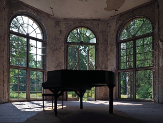 Klavier vor großen Fenstern